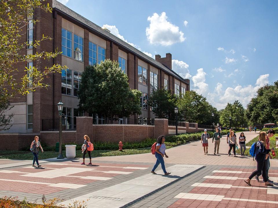 Student walk around the SMU Cox campus on a sunny day