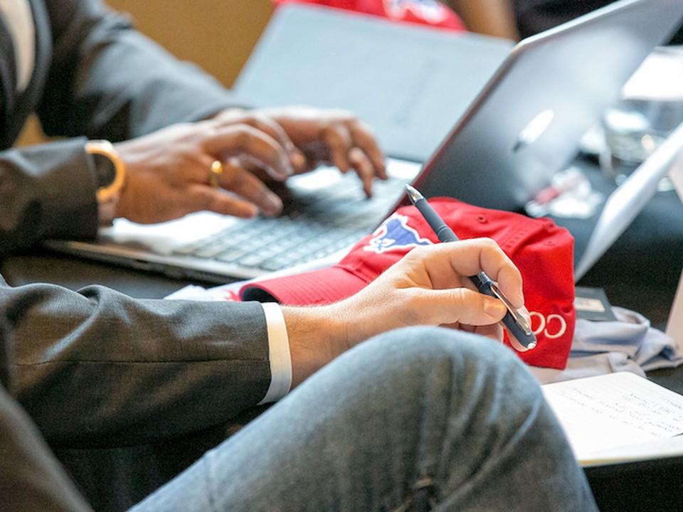 Two SMU Cox students sit together while working on a laptop